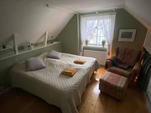 a bedroom with a bed and a chair and a window at Bekvämt boende mitt i gamla genuina Skärhamn in Skärhamn