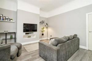 a living room with a couch and a television at Modern & Private Belgravia Apartment - Sleeps 4 in London