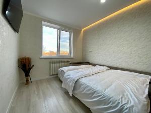 a bedroom with a white bed and a window at Dendrarium Studio in Chişinău