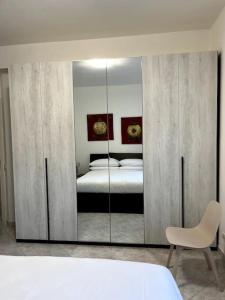 1 dormitorio con cama y espejo grande en Le case di Edo, en Latina