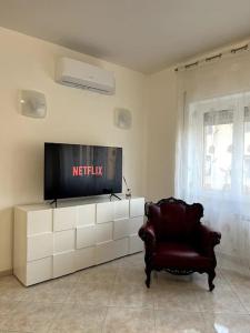 sala de estar con TV y silla en Le case di Edo, en Latina