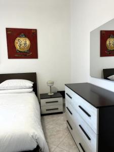 1 dormitorio con cama, tocador y espejo en Le case di Edo, en Latina