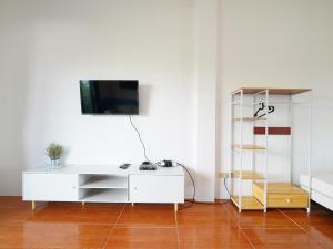 RoomQuest One Bangsaray في بانغ ساري: غرفة معيشة مع مكتب أبيض وتلفزيون