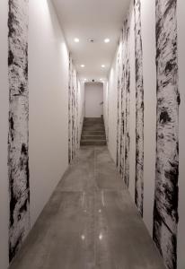 a long corridor with white walls and trees on the walls at Cà Murà - Residence Belle Parti in Padova