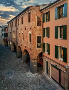 un antiguo edificio de ladrillo con arcos en un callejón en Cà Murà - Residence Belle Parti en Padua