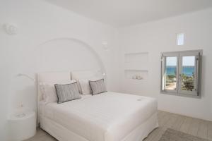 a white bedroom with a white bed and a window at White Dunes Luxury Boutique Hotel in Santa Maria