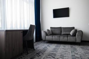 a living room with a couch and a television at AN Hotel in Šiauliai