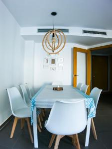 comedor con mesa azul y sillas blancas en Habitaciones privadas con baño en piso céntrico Gandía, en Gandía