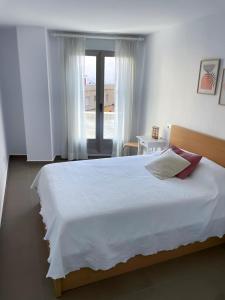 Un dormitorio con una gran cama blanca y una ventana en Habitaciones privadas con baño en piso céntrico Gandía, en Gandía