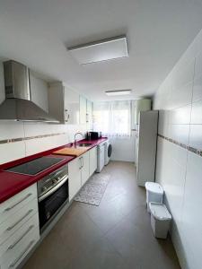 cocina blanca con fregadero y nevera en Habitaciones privadas con baño en piso céntrico Gandía, en Gandía