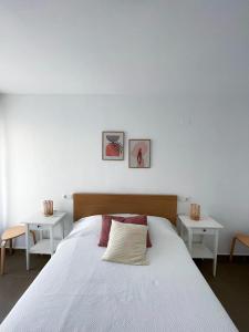 1 dormitorio con 1 cama blanca grande y 2 mesas en Habitaciones privadas con baño en piso céntrico Gandía, en Gandía