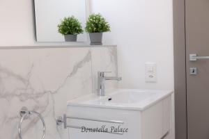 uma casa de banho com um lavatório e dois vasos de plantas em Elegant Apartments in Lugano em Lugano
