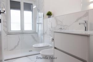 a white bathroom with a toilet and a sink at Elegant Apartments in Lugano in Lugano