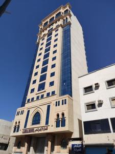 a tall building with a blue sky in the background at Al Azhar Almassi Hotel in Mecca