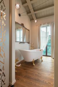 een badkamer met een wit bad en een spiegel bij Tenuta Zamparina in Montignoso