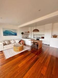 uma sala de estar com um sofá e uma mesa em Shed. Holiday Apartment em Nelson Bay