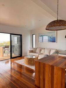 a living room with a couch and a table at Shed. Holiday Apartment in Nelson Bay