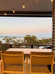 a table and chairs with a view of the ocean at Shed. Holiday Apartment in Nelson Bay