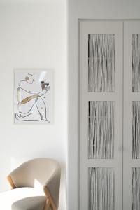 a white room with a chair next to a door at White Dunes Luxury Boutique Hotel in Santa Maria