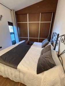 1 dormitorio con 1 cama grande y cabecero de madera en Casa Pozo de la Nieve, en Iznatoraf