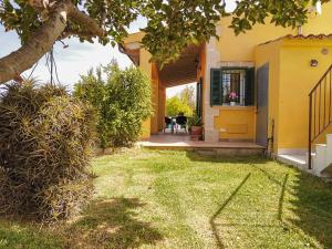 una casa amarilla con ventana y patio en Son Serra country villa for 4 near Buger, en Búger