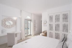 a white bedroom with a bed and a mirror at White Dunes Luxury Boutique Hotel in Santa Maria