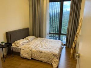 ein Schlafzimmer mit einem Bett und einem großen Fenster in der Unterkunft The Ridge at KL East - NatureBackdoor in Kuala Lumpur