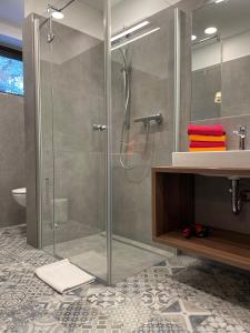 a bathroom with a glass shower and a sink at Villa Emilia in Kals am Großglockner