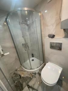 a bathroom with a glass shower and a toilet at Hostel BYTOMSKA in Września