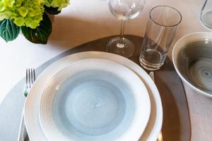 a table with a blue bowl and plates on a table at Residence Engel in Nova Levante