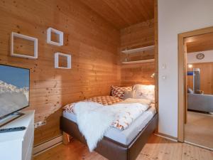 a bed in a room with wooden walls at Appartement Musik-Neureiter in Söll