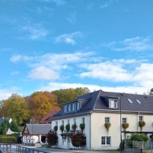 une maison blanche avec un toit noir dans l'établissement Landhotel Waldschlößchen, à Sohland