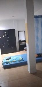 a room with a blue bed and a mirror at J&E in Nong Prue