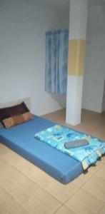 una cama azul sentada en el suelo en una habitación en J&E, en Nong Prue