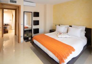 - une chambre avec un grand lit et une couverture orange dans l'établissement Enoturismo Celler Piñol, à Batea