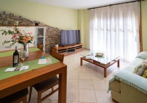 - un salon avec une table et une télévision dans l'établissement Enoturismo Celler Piñol, à Batea