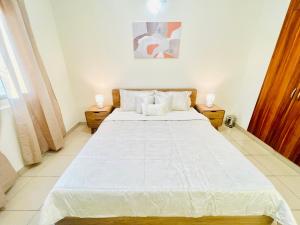 a bedroom with a large white bed in a room at Cozy 1 Bedroom apartment in Dubai by Al Ghaimah Holiday Homes in Dubai