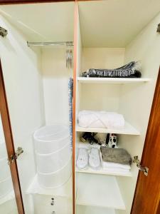 a walk in closet with white shelves and towels at Cozy 1 Bedroom apartment in Dubai by Al Ghaimah Holiday Homes in Dubai