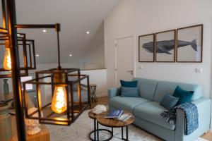 a living room with a blue couch and a table at Varanda Azul - Lookout Loft (City Centre) in Ponta Delgada