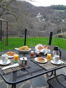 een tafel met borden eten en drinken erop bij chambre d'hôtes Cadravals Belcastel Aveyron in Belcastel