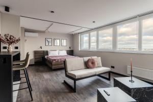 ein Schlafzimmer mit einem Bett, einem Sofa und einem Stuhl in der Unterkunft 77 views apartments by INSHI in Lwiw
