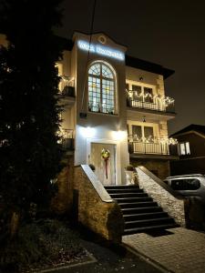 a lit up building with stairs in front at night at Apartamenty Willa Krakowska in Raszyn