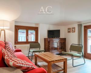 a living room with a red couch and a tv at Square Apartment in Ponte di Legno