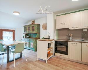 a kitchen with a table and a dining room at Square Apartment in Ponte di Legno