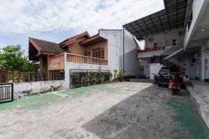 una casa con un coche aparcado delante de ella en RedDoorz Syariah near RSUD Zainoel Abidin Banda Aceh en Banda Aceh