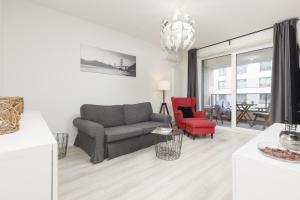 - un salon avec un canapé et un fauteuil rouge dans l'établissement Business Apartment Mokotów by Noclegi Renters, à Varsovie