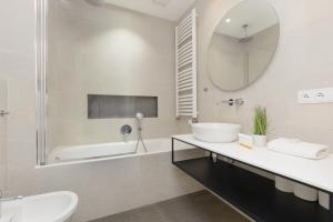 une salle de bain avec un lavabo, une baignoire et un miroir dans l'établissement Business Apartment Mokotów by Noclegi Renters, à Varsovie 24 autres photos