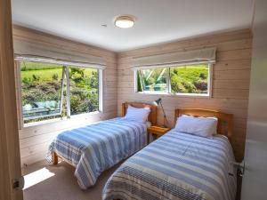 two beds in a room with two windows at Paddock House - Motueka Holiday Home in Motueka