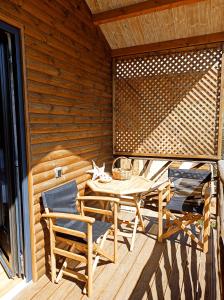 una terraza de madera con mesa y sillas. en Kartalia wooden maisonette, en Porto Koufo