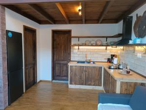 cocina con armarios de madera y nevera negra en Kartalia wooden maisonette, en Porto Koufo